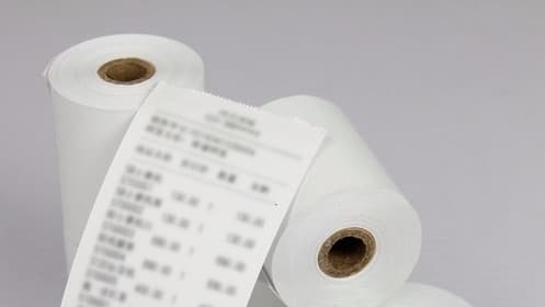 Pila de rollos de papel térmico, empleado en tacógrafos digitales para imprimir actividades registradas.